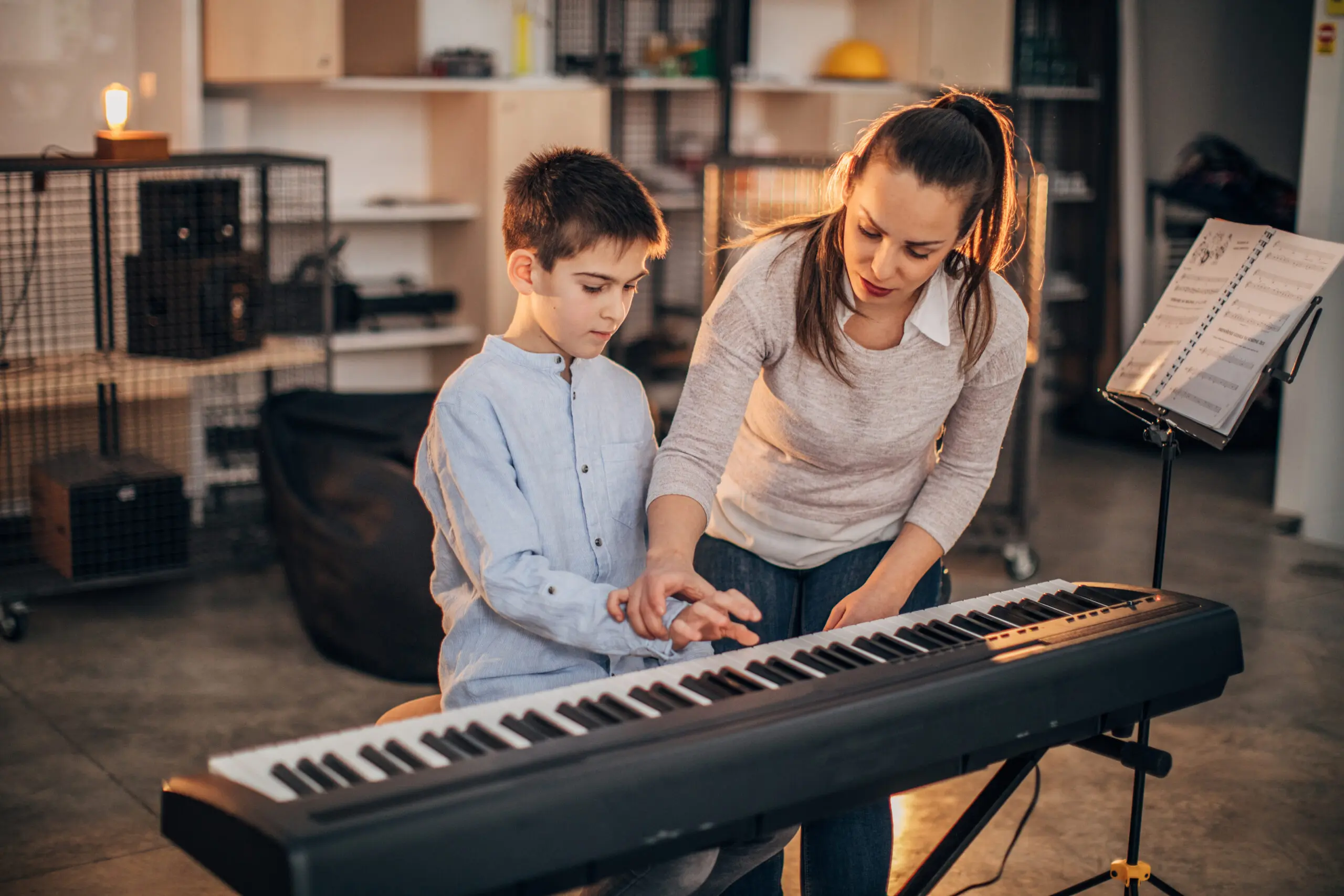 Child learning piano with teacher's guidance
