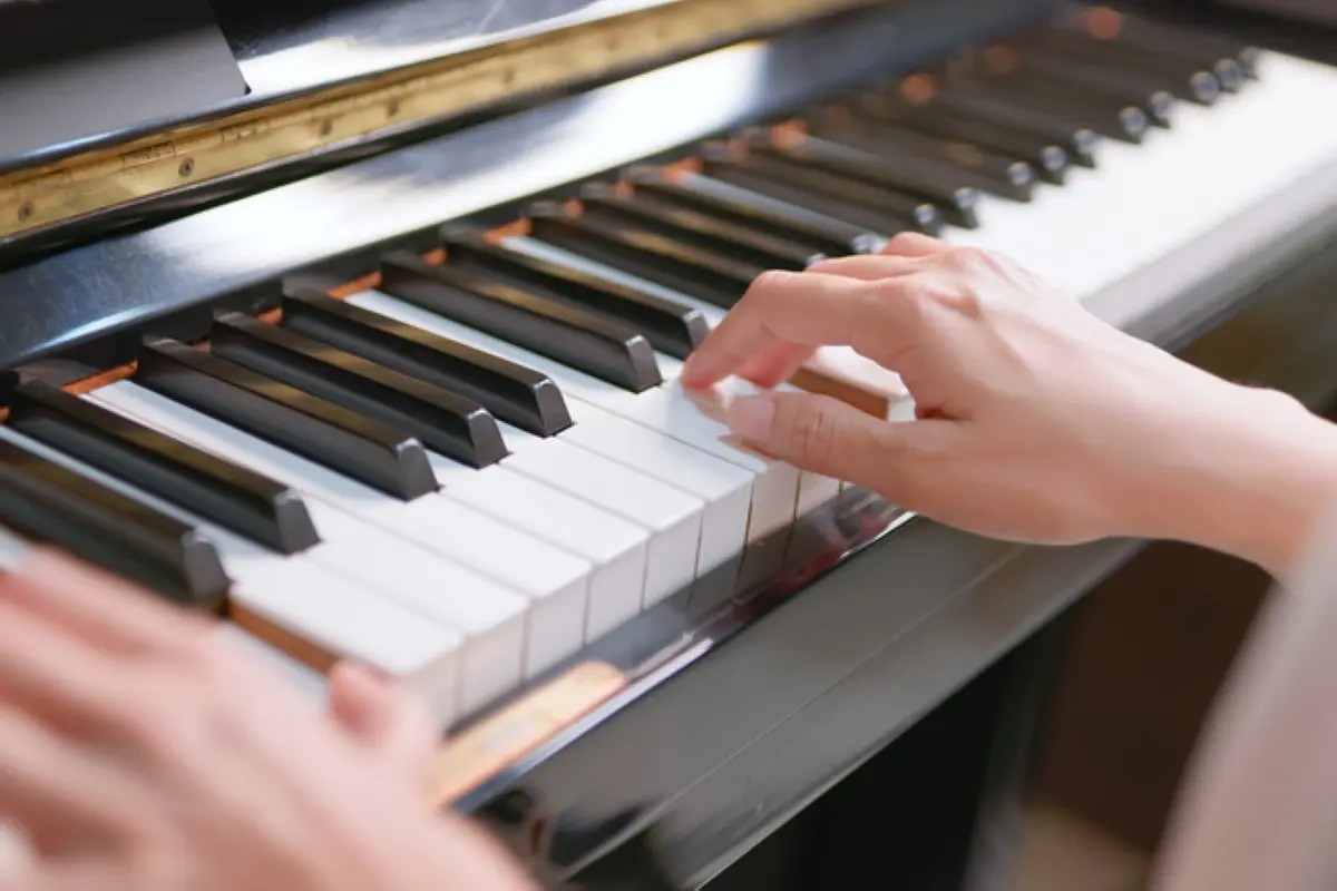 Hands playing piano keys