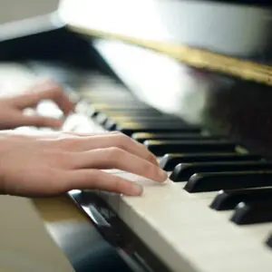 Hands playing piano keys