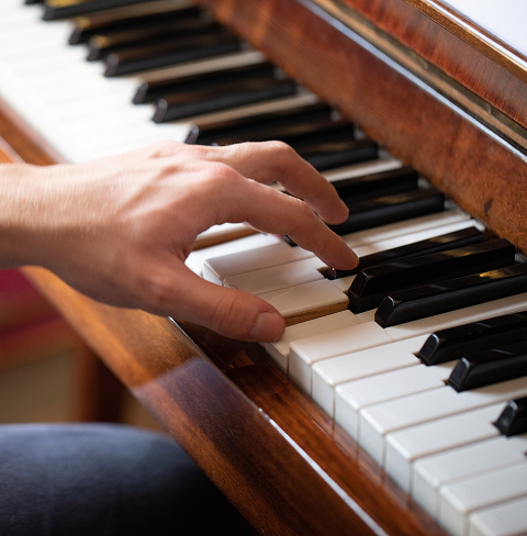 Pianist's hand on wooden piano keys