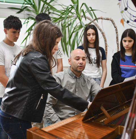 Group piano lesson with focused students
