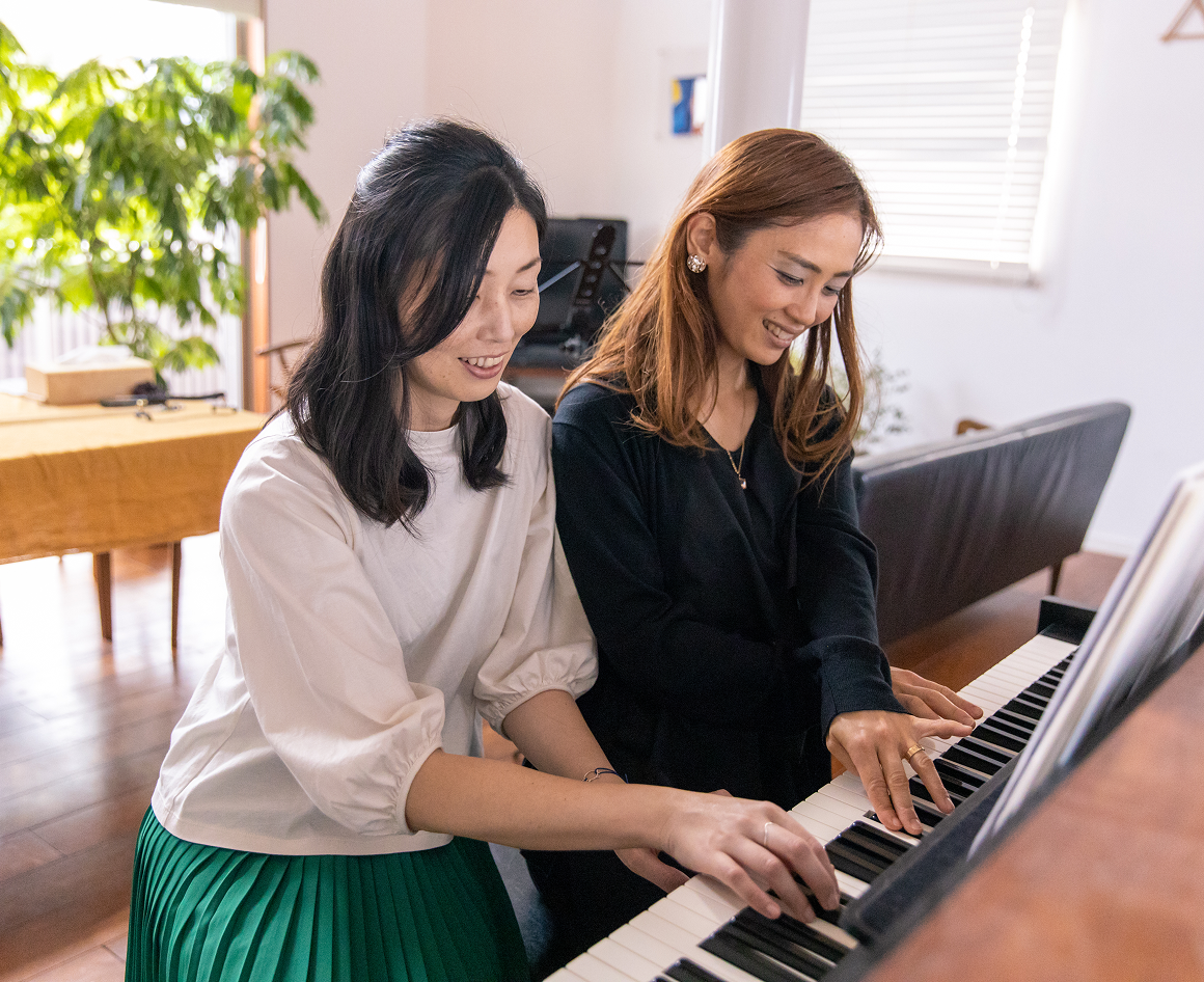 Women smiling while playing piano