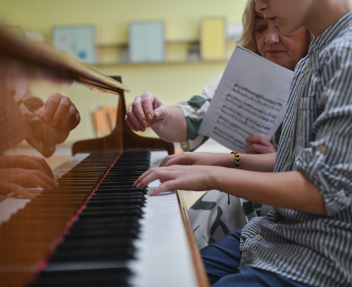 Teacher helping student at piano