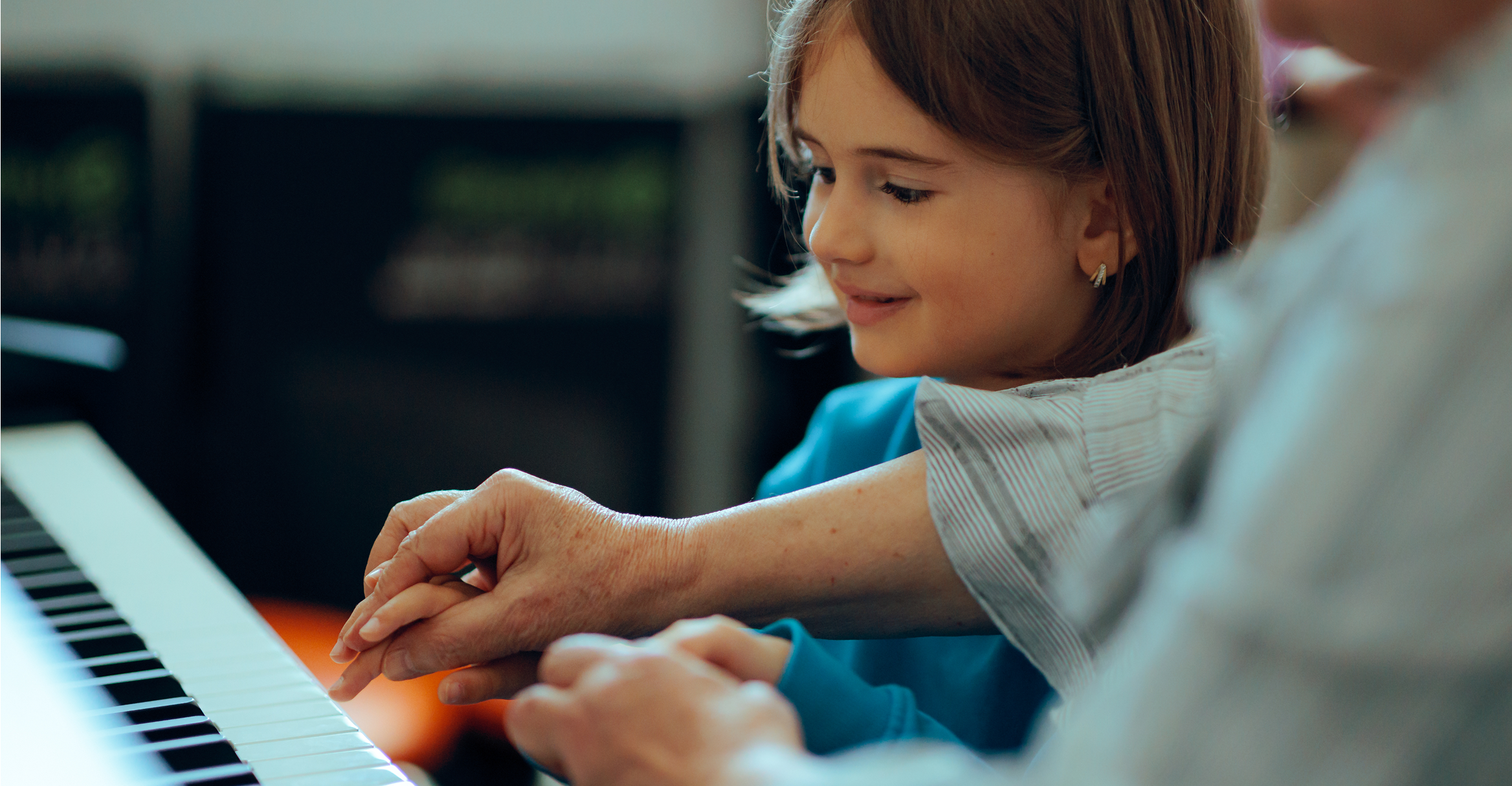 Young girl practicing piano with mentor