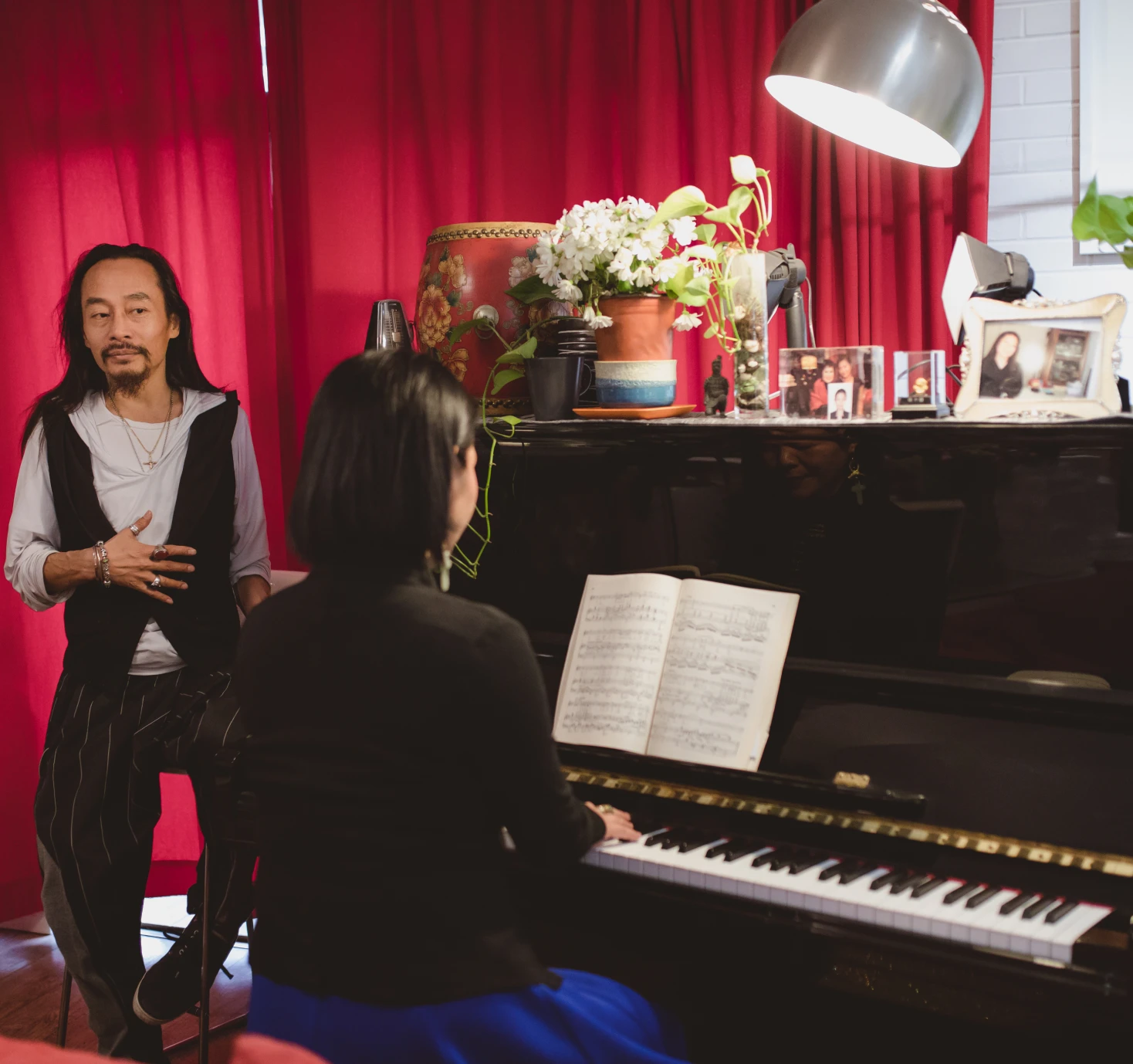 Person playing piano with an observer