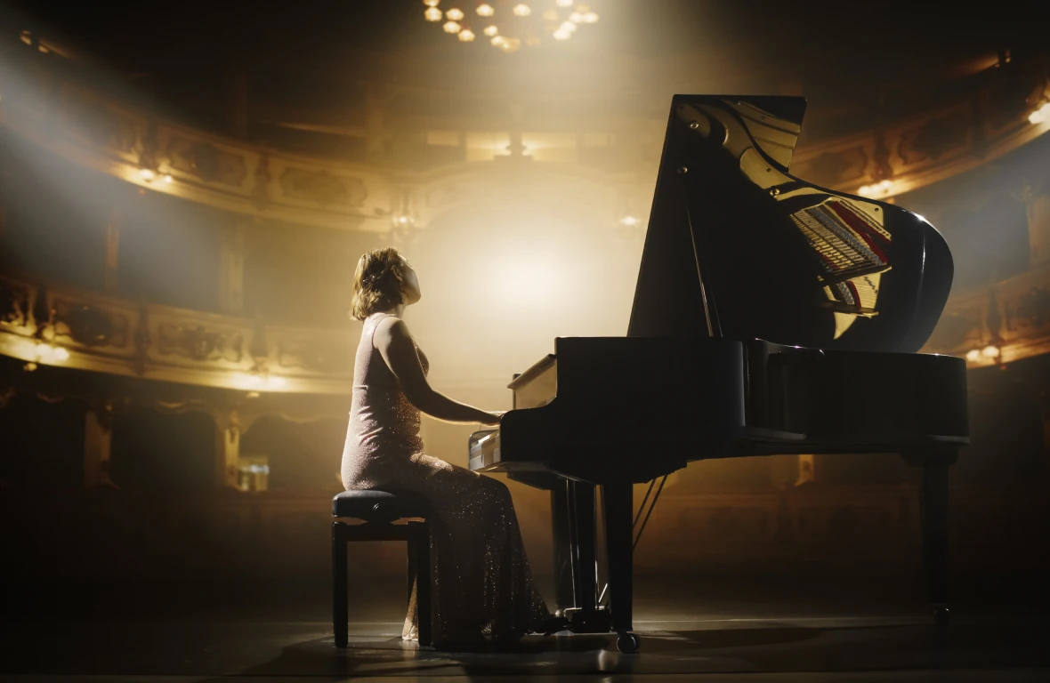 Pianist performing on grand piano stage